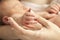 Closeup view of newborn\'s hand holding mother\'s thumb