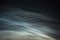 Closeup view of  noctilucent clouds. Beautiful waves and ripples of silver blue night shining clouds houses in summer