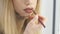 Closeup view of a professional makeup artist applying lipstick on lips