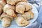 Closeup view of ruddy sugar-frosted croissants from a curd dough lying on a white plate next to a gray cloth. Sweet baked bagels