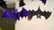 Closeup view shiny plastic bat decoration hanging on ceiling lamp for halloween celebration