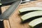 Closeup view on sliced cucumbers and knife on the wooden boaard