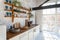Closeup view on a spacious loft industrial open space kitchen studio interior with kitchen appliances and big windows