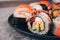 Closeup view of sushi rolls with salmon, avocado and smocked eel on the concrete table background - futomaki. uramaki