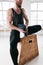 Closeup view on sweaty muscular man sitting on box in crossfit gym