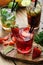 Closeup view of sweet lemonades served with straws on wooden table and chopping board.