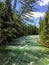 A closeup view of the turquoise waters of Athabasca River surrounded by evergeen forest, along the Maligne Canyon trail in Jasper