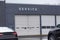 Closeup view of two overhead garage doors with the word service on the gray wall above one of the doors