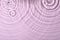 Closeup view of water with rippled surface on violet background