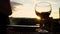 Closeup view of wine glass standing on picnic table on sunset background and man taking another one