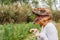 Closeup view of woman with dinosaur head mask in vegetables garden.Copy space