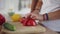 Closeup view of woman`s hands cutting vegetables while african man`s hands helping her. Happy multiethnic couple in the