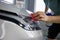 Closeup view on worker-detailer hands applying protective film on car headlight