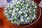 A closeup view of wrapped starlight mint hard candies in a clear glass or plastic bowl on a wooden table