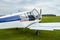 Closeup view of Zlin Z-43 four-seat airplane standing on a grass runway.