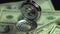 Closeup of vintage pocket watch hanging above money, precious time passing by