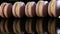 Closeup violet french macarons stand on edge in row with reflection