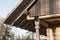 Closeup of wall frame finish with burned timber planks on log house attic and the rafters on log house roof construction