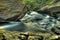 Closeup of Water Stream Moving Through Rocks