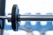 Closeup weight plate fixed on barbell in gym