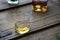 Closeup of whisky glass and bottle on a shabby wooden barrel