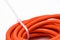 Closeup of a white cable tie tied to a roll of orange cable wire