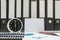 Closeup white clock for decorate in 6 o`clock desk of officer with work paper and document file in office room textured backgroun