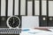 Closeup white clock for decorate in 7 o`clock desk of officer with work paper and document file in office room textured backgroun