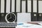 Closeup white clock for decorate in 8 o`clock desk of officer with work paper and document file in office room textured backgroun