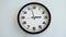Closeup of White Clock Face on white wall clock, arrows show 15:00 or 03:00