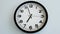 Closeup of White Clock Face on white wall clock, arrows show 19:00 or 07:00