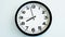 Closeup of White Clock Face on white wall clock, arrows show 20:00 or 08:00