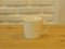 Closeup White Cofee Cup on the wooden table with White Brick wall background.