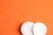 Closeup of white cotton discs on an orange background