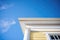 closeup of white georgian cornice with dentil molding against a blue sky