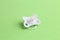 Closeup of a white pacifier isolated on a green background
