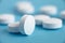 Closeup of white pills on a blue background. Heap of pills - medical background