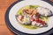 Closeup of a white plate of Mexican traditional gourmet food on a wooden table