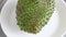 Closeup of whole green soursop graviola, exotic, tropical fruit Guanabana on plate