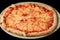 closeup whole sliced four cheese pizza on black background