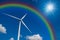 Closeup Wind turbine power generator with rainbow on blue sky