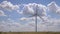 Closeup of windmills against blue sky and white clouds