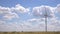 Closeup of windmills against blue sky and white clouds