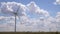 Closeup of windmills against blue sky and white clouds