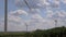 Closeup of windmills against blue sky and white clouds