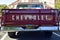 Closeup of a Wine Colored 1965 Classic C-10 Chevy Pickup Truck and white top with hood up