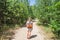 Closeup of woman with backpack on trailway in fir and pine trees forest. Concept of active lifestyle, hiking and tourism