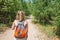 Closeup of woman with backpack on trailway in fir and pine trees forest. Concept of active lifestyle, hiking and tourism