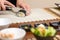 Closeup of woman chef cutting japanese sushi roll