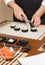 Closeup of woman chef cutting japanese sushi roll